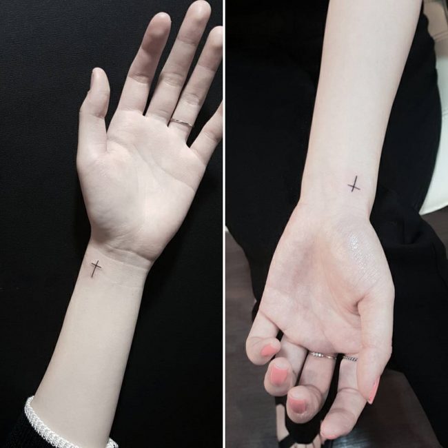 Small Black Cross Tattoo On Girl Left Wrist